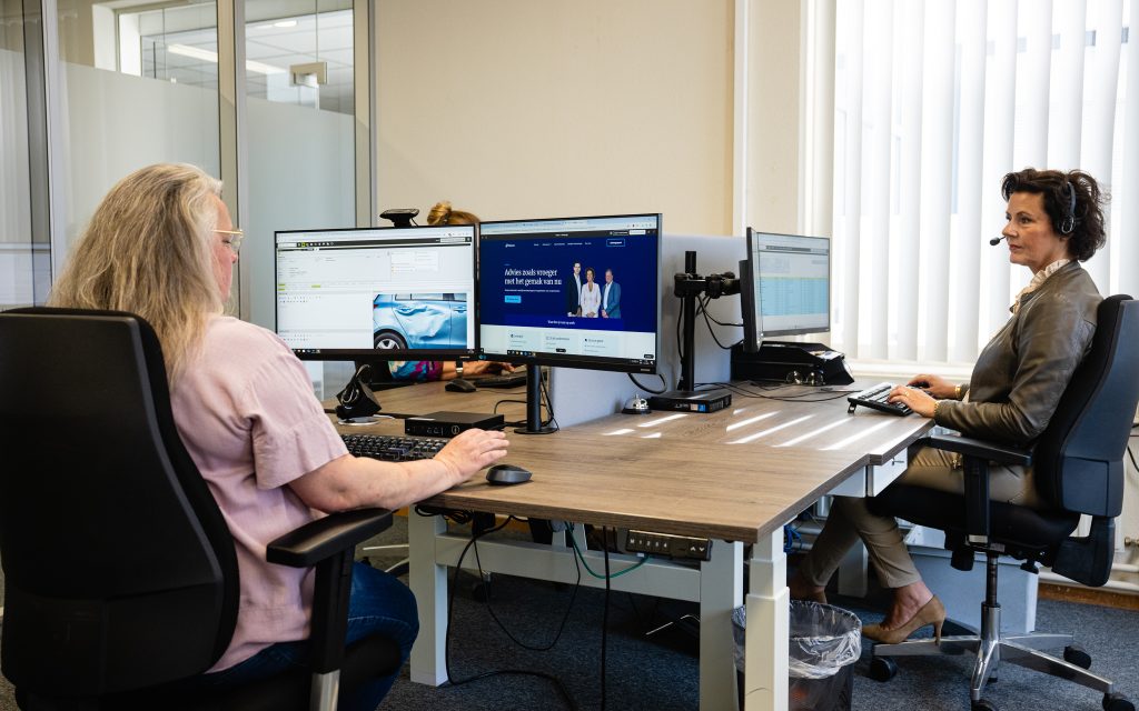 Twee vrouwen werken op kantoor met computers.