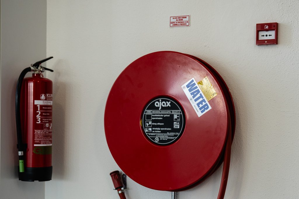 Brandblusser en brandslanghaspel aan de muur